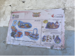 A faded Action Against Hunger poster of nutritional information hangs on one of the remaining walls